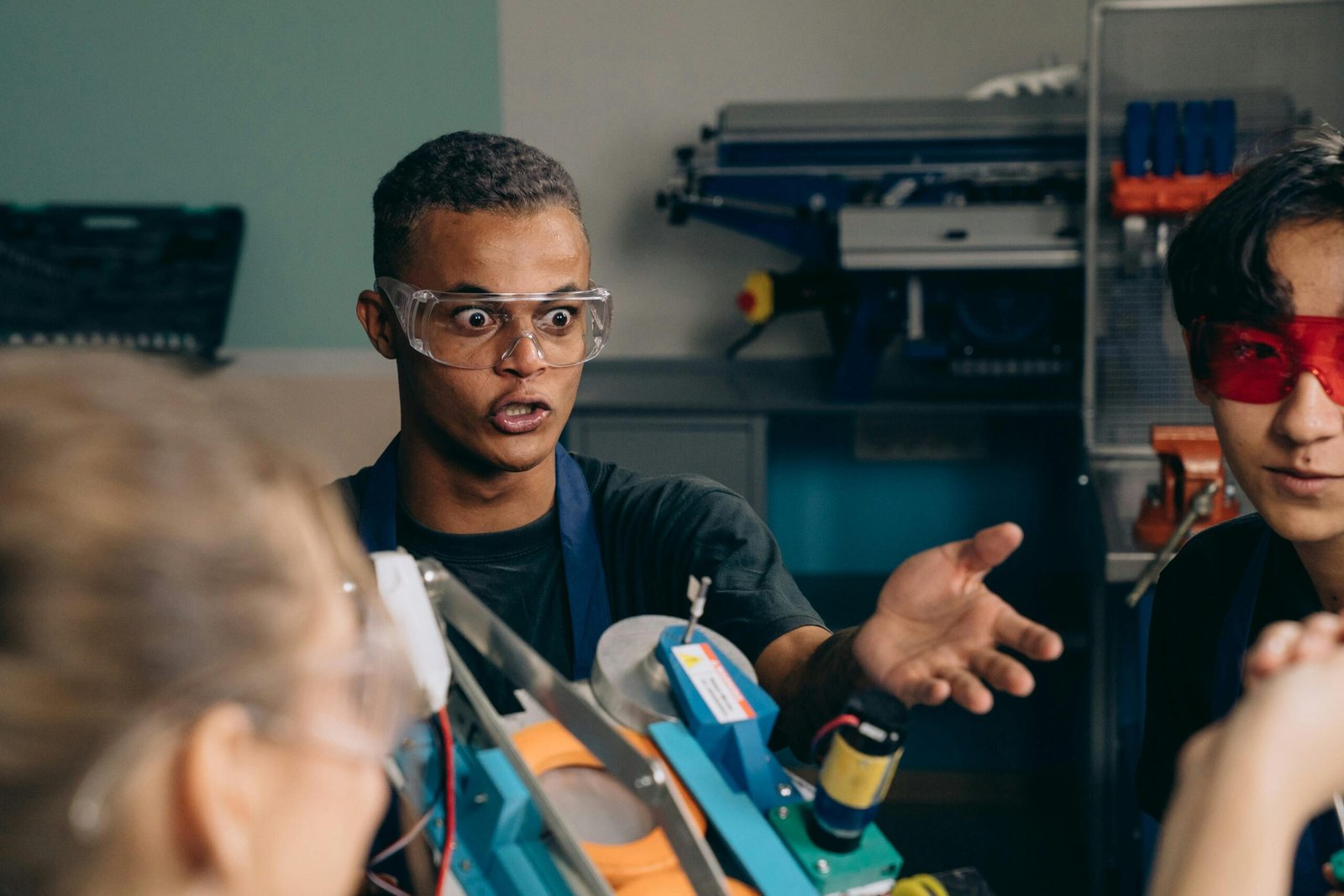 A young engineer passionately discussing a robotics project in a workshop setting.