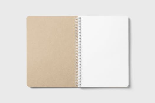 An open spiral-bound notebook with blank pages, ideal for note-taking or design mockups.